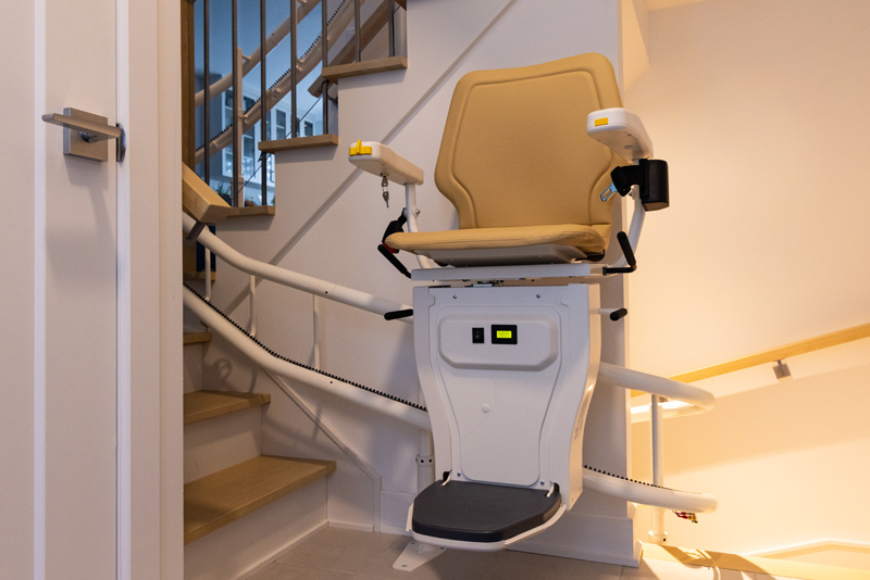 Curved stairlift traveling along winding staircase