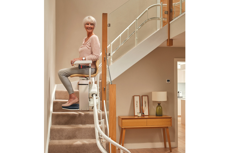 Curved stairlift in use — smooth ride around bends